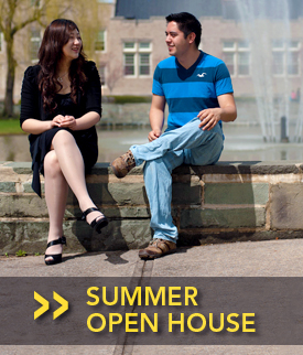 Photo of students sitting on a bench in from of Hawkins Pond