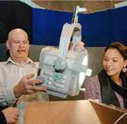 Students look on as TV Studio Manager Jon Chew tests one of the donated lights