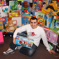 Photo of SUNY Plattsburgh graduate student Brian Ensel, sitting on the floor, surrounded by toys