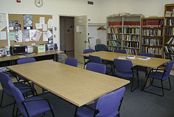 View of the furniture, which includes two conference tables, chairs, microwave and well-stocked bookcases