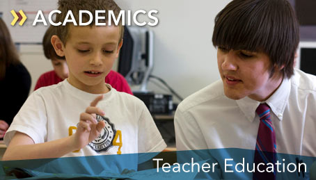 Photo of a student working with a child in class