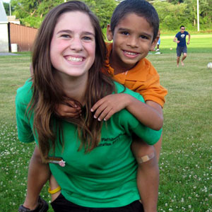 Photo of student with younger brother on soccer pitch