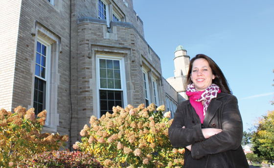 Photo of Alisa Woods standing in front of Hawkins Hall