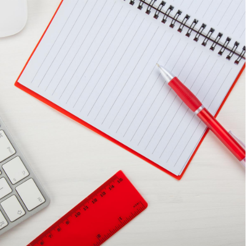 Notepad, red pen and ruler.