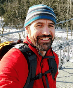 Portrait of Dennis Delay on a hike in the snow