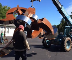 Jason Roth watches as his sculpture is moved outdoors