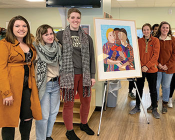 Art students pose next to a painting the SA purchased