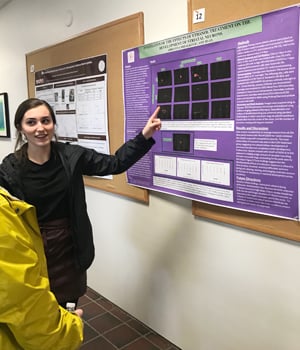 Abrianna explains a poster to visitor