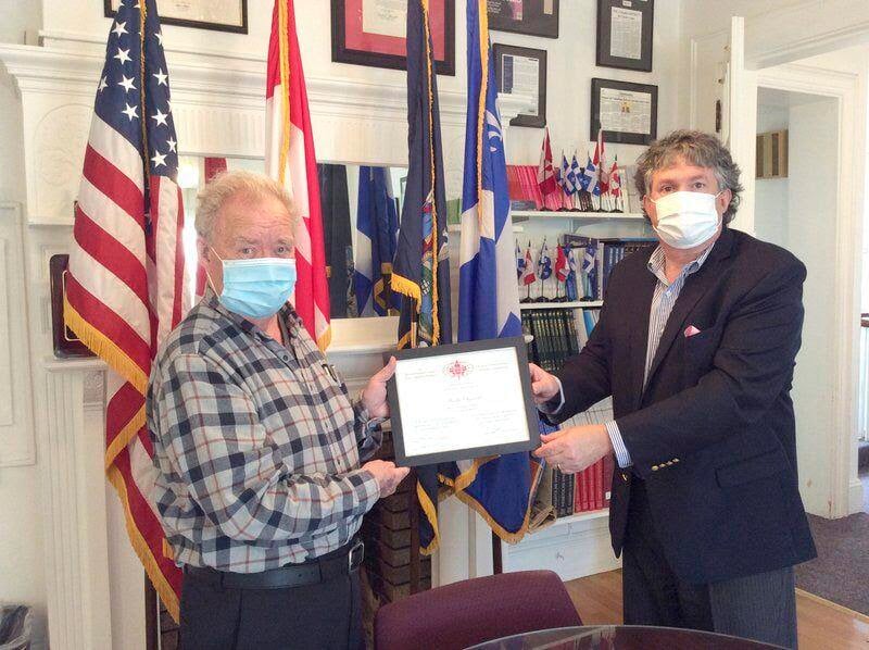 Dr. Joseph Andre Seneca accepts certificate of merit from Christopher Kirkey