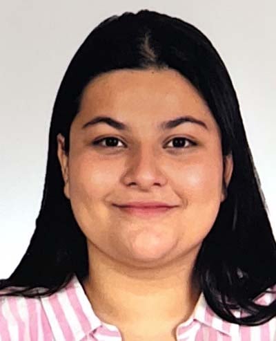 the photo is of a young Indian woman smiling with a pink striped shirt