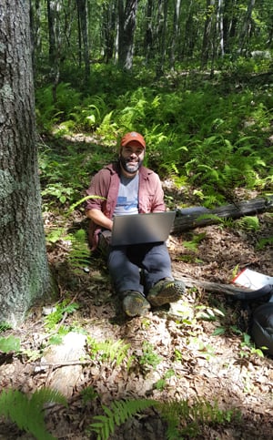 Portrait of Dr. Lesser doing research in a forest