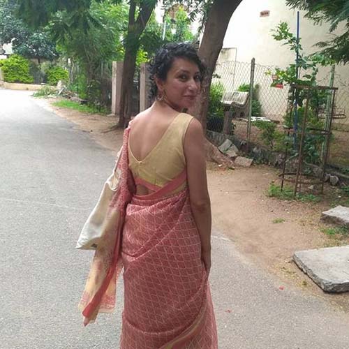 Woman walking on a street, back to the camera, turns her head over her shoulder