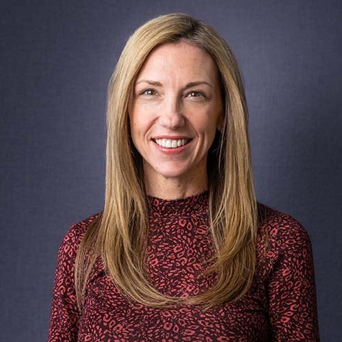 Woman with long, blond straight hair smiles brightly for the camera