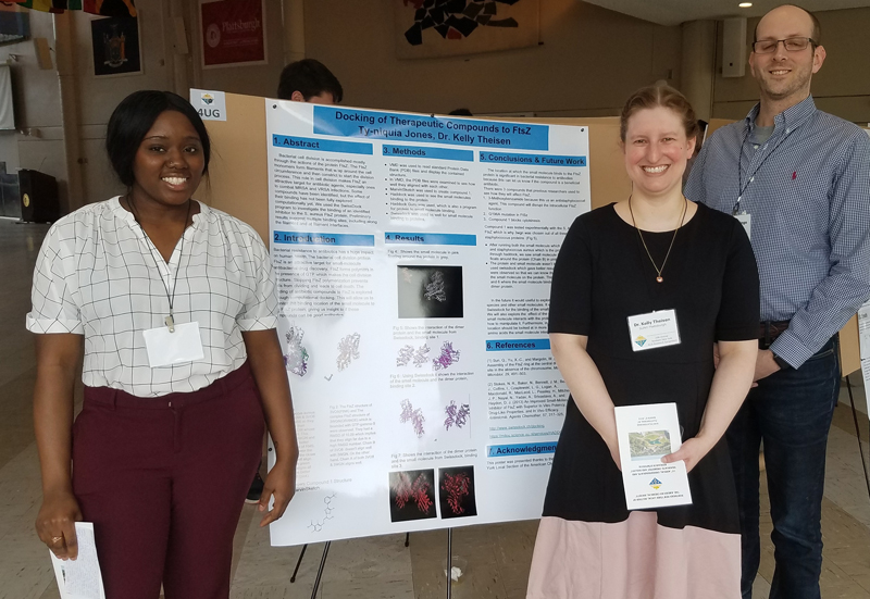 Kelly Theisen presents a poster with students at an ACS event