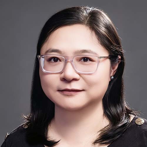 Woman with long dark hair sits for a professional headshot
