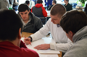 Tim Mulligan, a mathematics teacher at Plattsburgh High School, discusses a contest problem with some of his students. Photo by Jessica Karszen