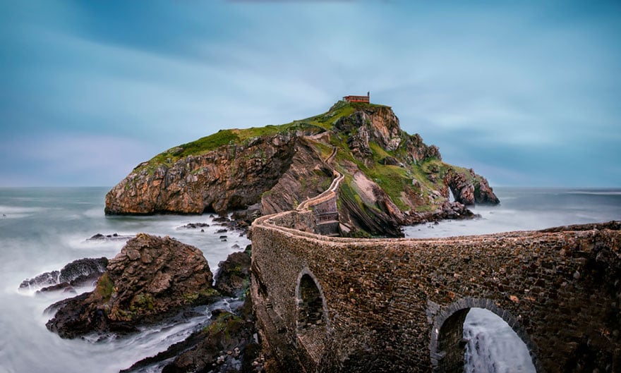 View of an old stone bridge spanning a rocky coast to a small island