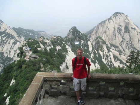 A student poses for a photo in the mountains