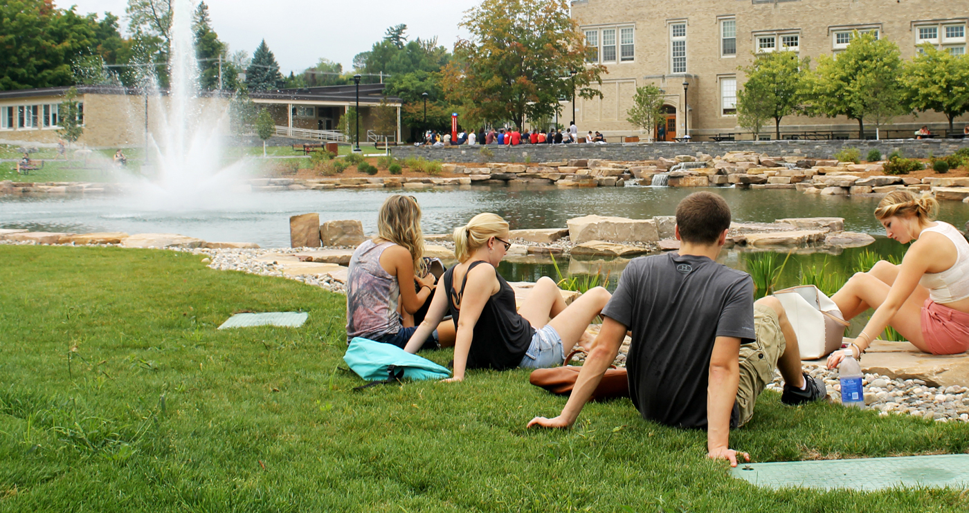 Students havign a picnic on campus in front of Hawkins Ponf 