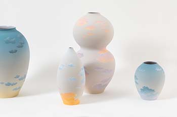 Ceramic vases of various sizes and rounded shapes with ethereal glazes that look like sky and clouds