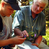 Photo of Ken Adams working in the field with student