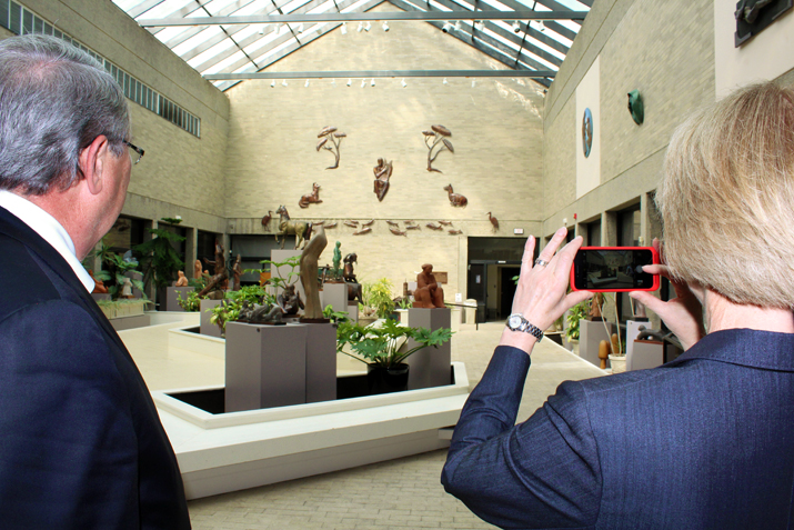 Photo of new Chancellor Kristina Johnson and President John Ettling taking photos in the Winkel Sculpture Court