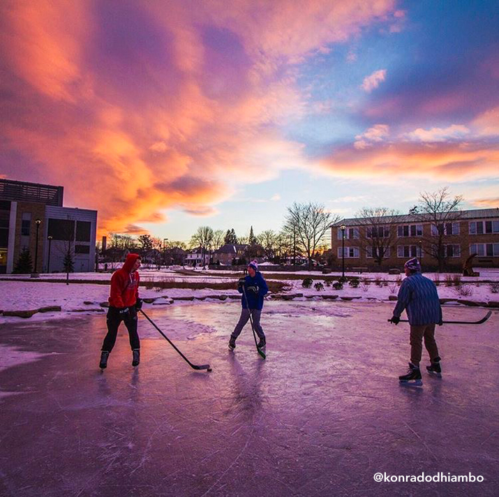 Photo of students playing pick-up hockey on the ice of frozen Hawkins Pond by konradodhiambo