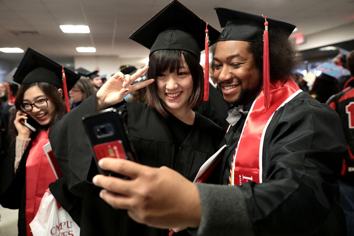 Students celebrating graduation with a selfie.