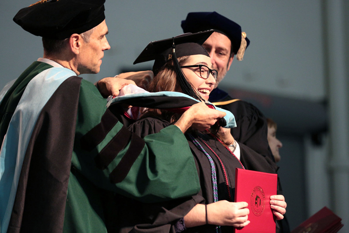 Student on stage recieving her diploma