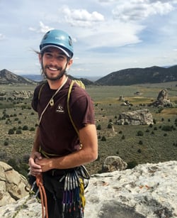 Photo of Keith Madia rock climbing outdoors in a remote area