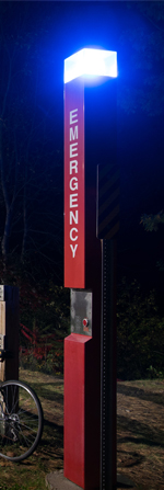 A blue light phone at night along the Saranac River Trail